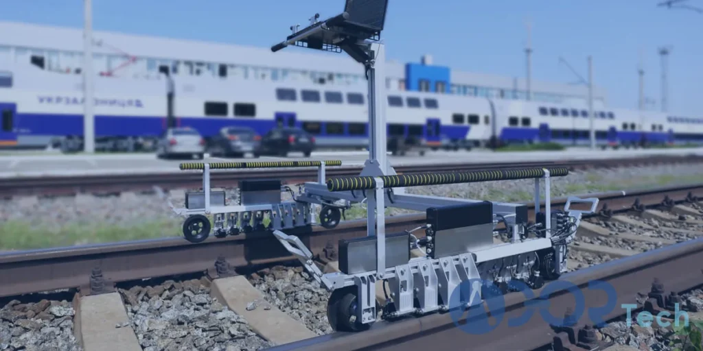 A portable eddy current testing system positioned on railway tracks, using sensors and a mounted computer to inspect rail surfaces near a train station.
