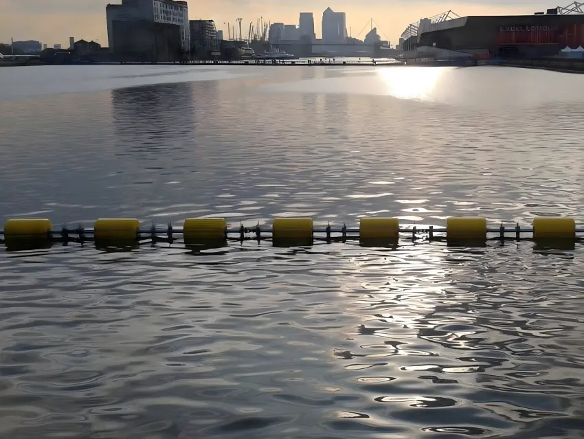Floating security barrier across harbor water
