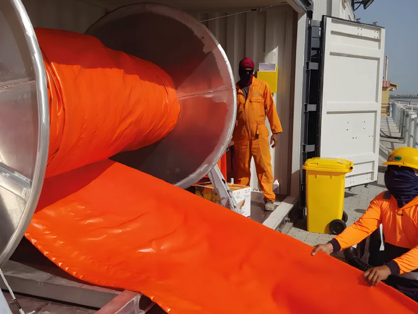 Inflatable oil boom deployment from storage reel