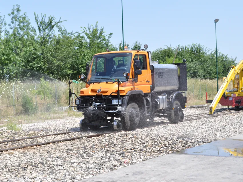 Hi rail truck spraying water on railway tracks for cleaning and maintenance work.
