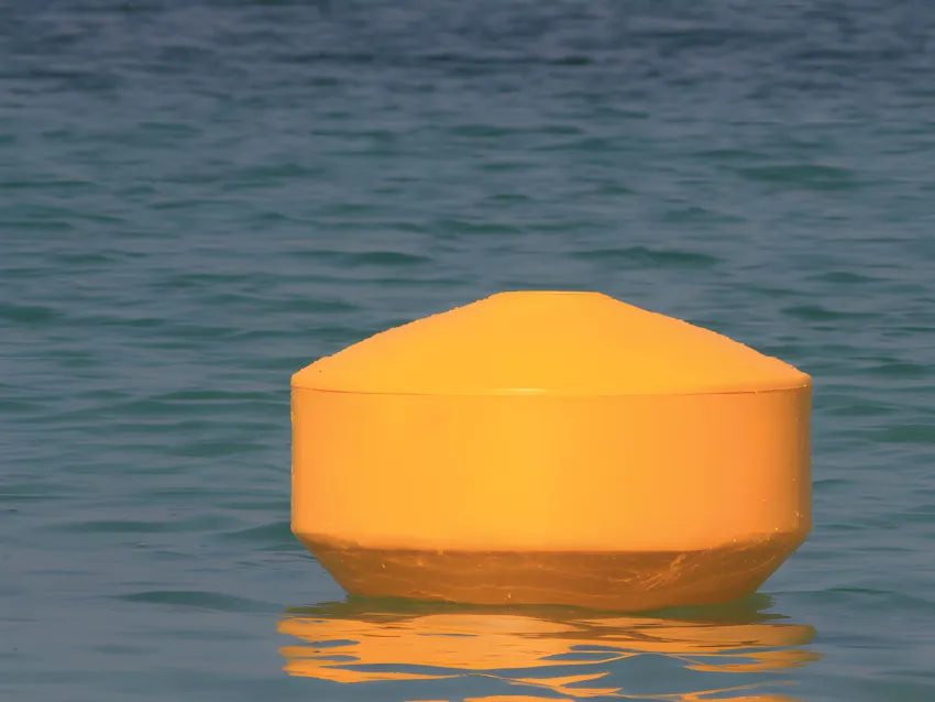 Yellow mooring buoy floating on water