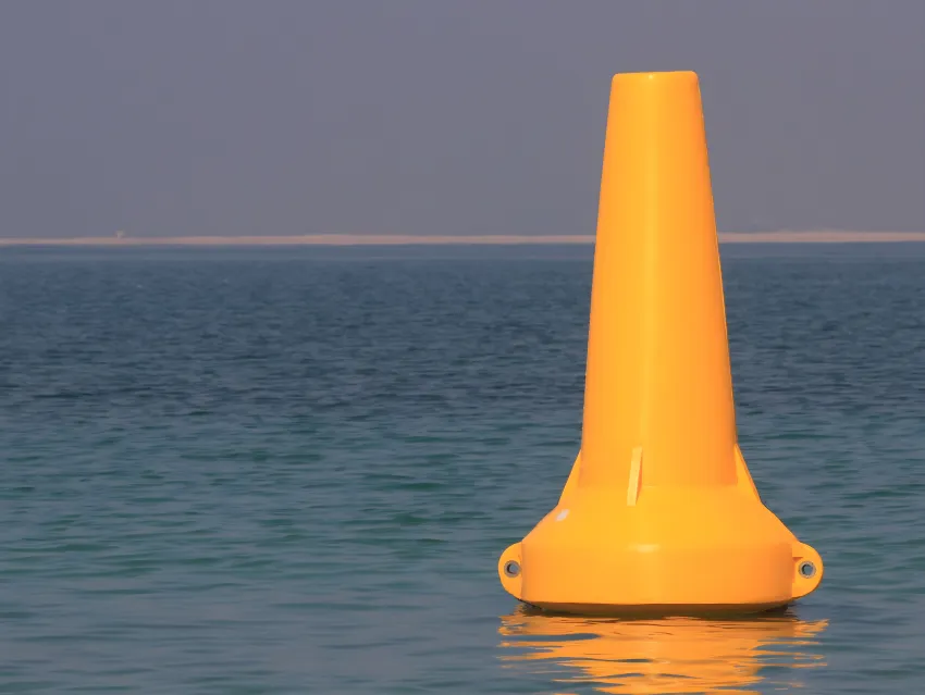 Yellow navigation buoy floating on water