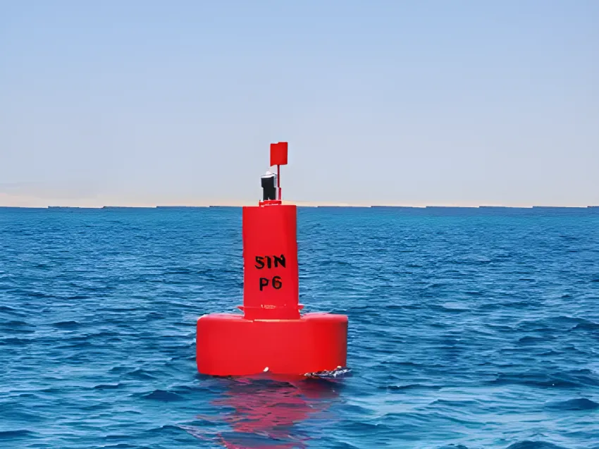 Red navigation buoy floating on open water