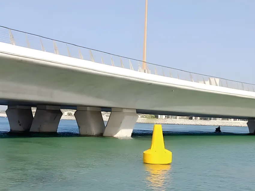 Yellow navigation buoy under bridge