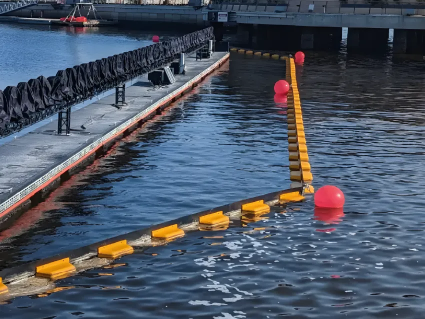 Permanent oil boom around marina dock