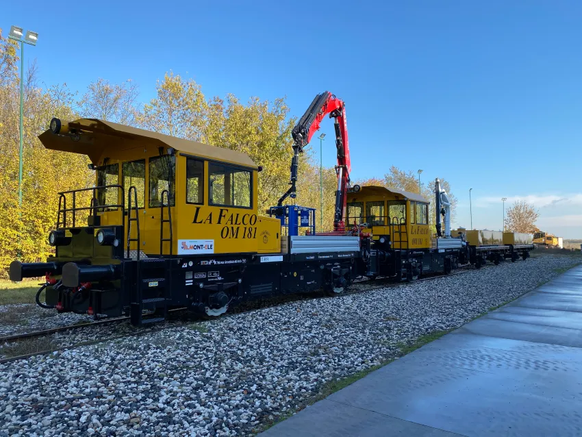 Railway shunters on tracks with crane attachments for rail yard operations and industrial switching work.
