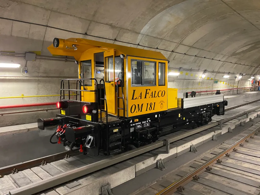 Electric shunter operating on railway tracks inside a tunnel for rail switching and maintenance support.