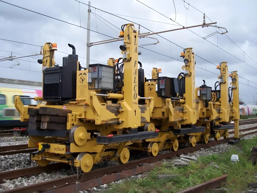 Railroad track laying machine on railway tracks for rail installation.