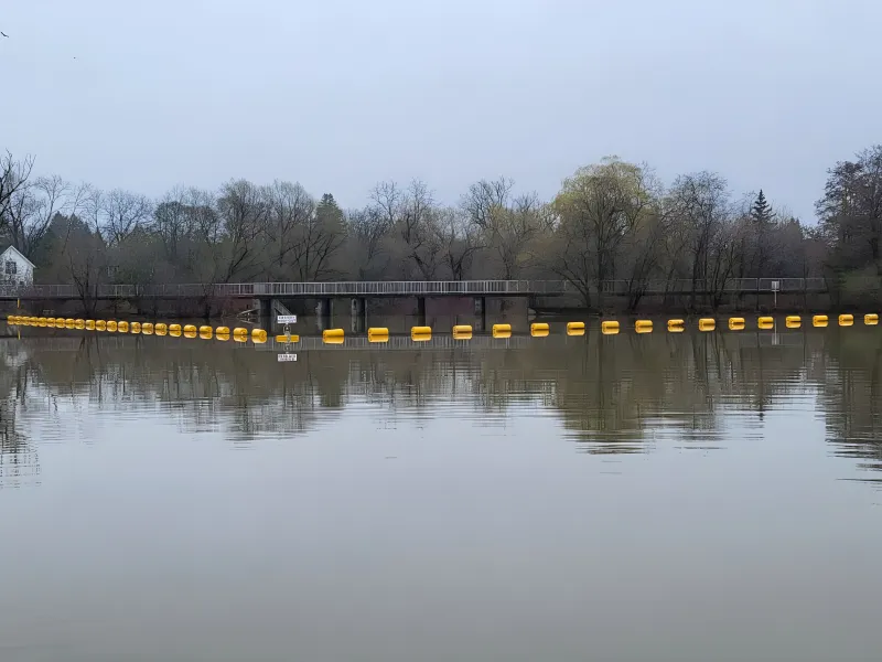 Waterway barrier installed across a river for watercraft safety and traffic control.
