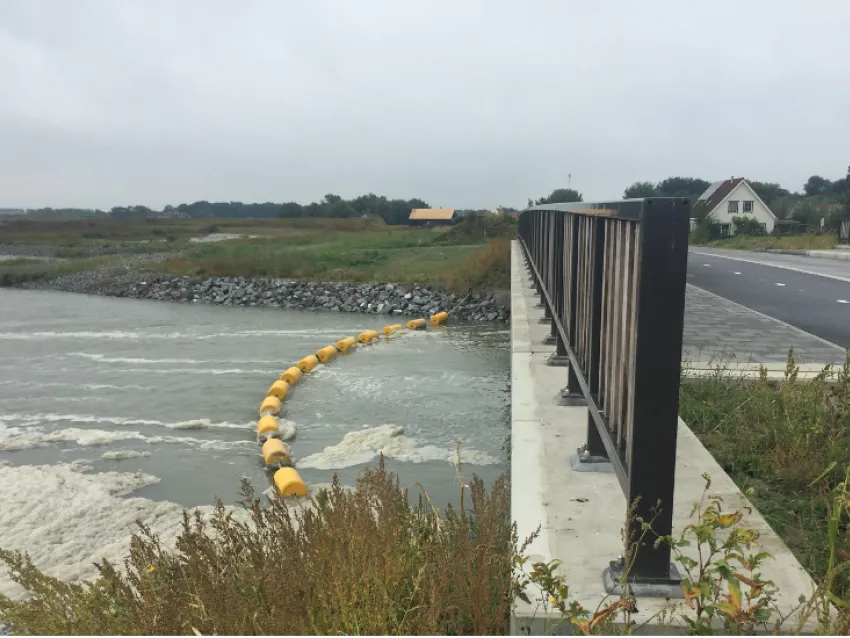 Waterway barrier installed near a bridge for watercraft safety and water traffic control