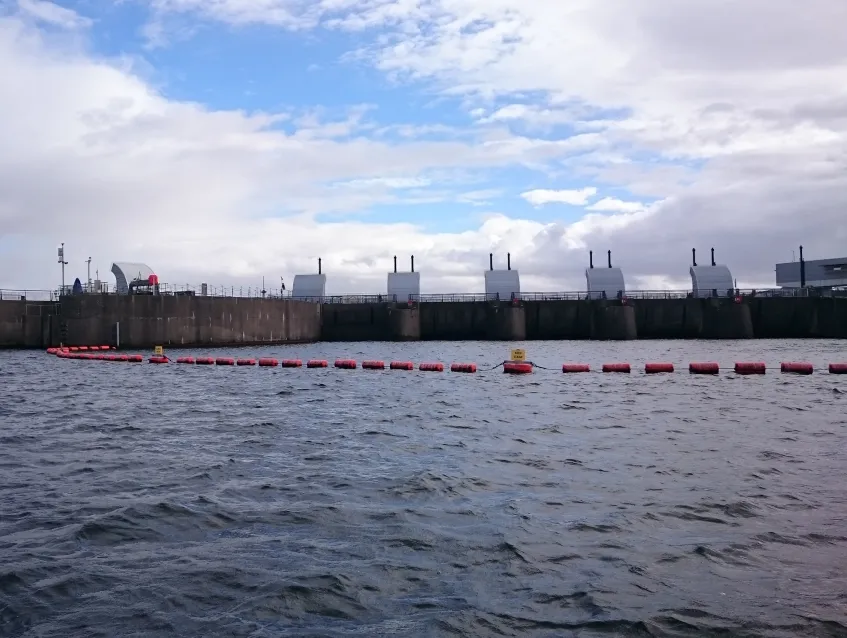 Waterway barrier installed near a dam for watercraft safety and traffic control