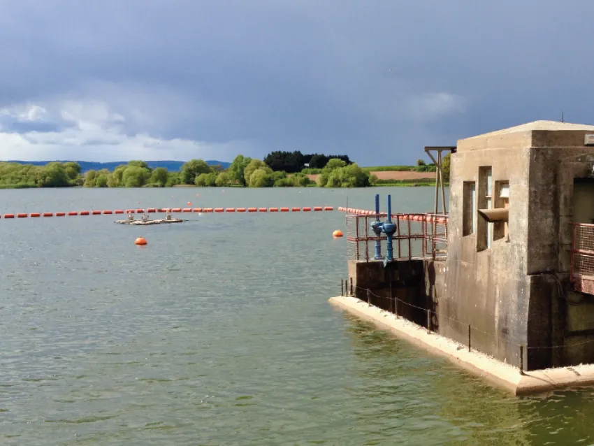 Waterway barrier installed near water infrastructure for watercraft safety and traffic control